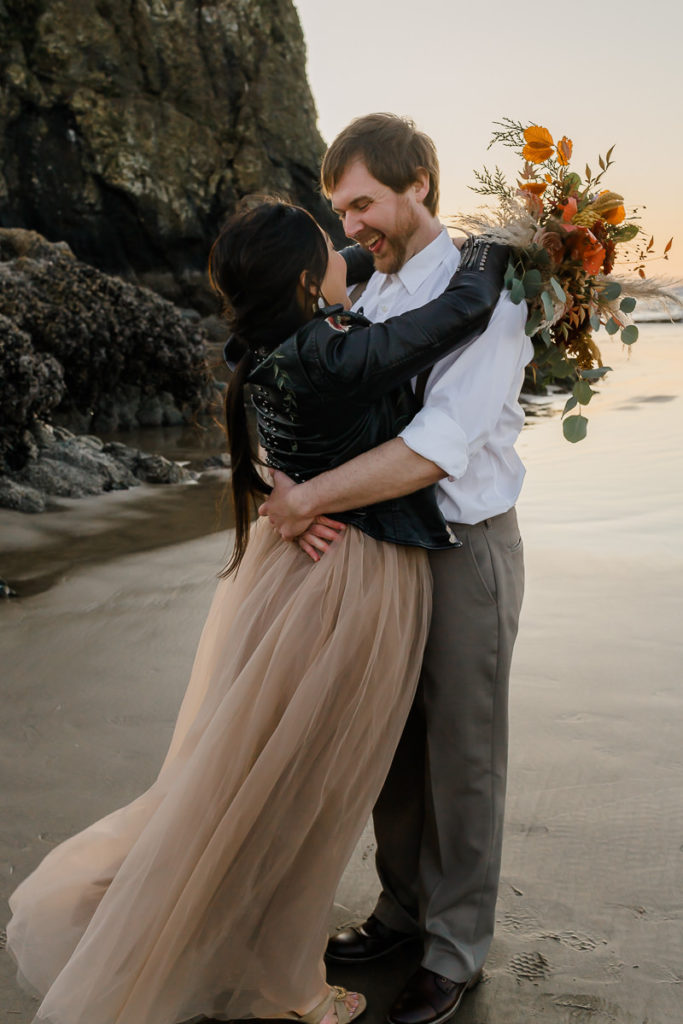 bride and groom together in front of haystack rock at cannon beach