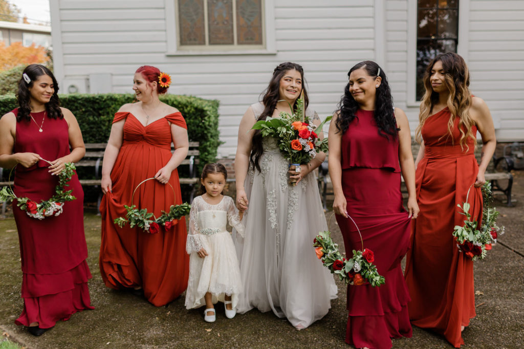 bride and bridesmaids in mixed red gowns