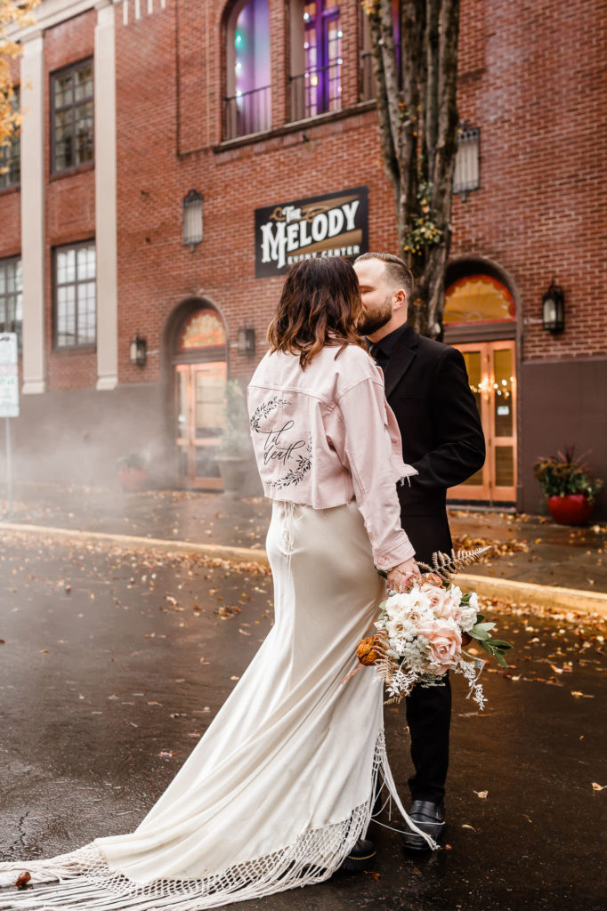 bride and groom sharing a kiss outside of downtown portland wedding venue
