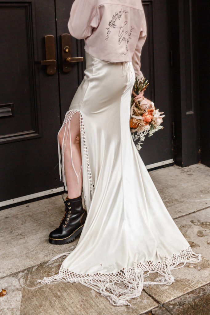 close up of bride's silk and fringe wedding dress