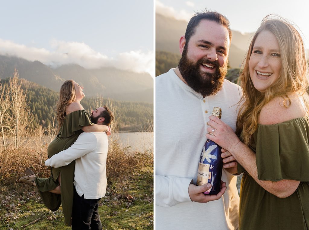 Man holding lady up with trees and lake behind them and couple holding bottle of Champaign Government Cove Oregon Engagement Photography captured by Oregon Engagement Photographer Simply Wandering Photography 