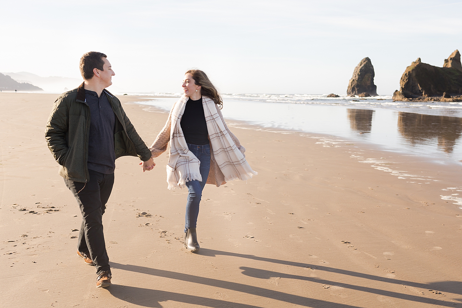 Couple holding hands and walking on the sand