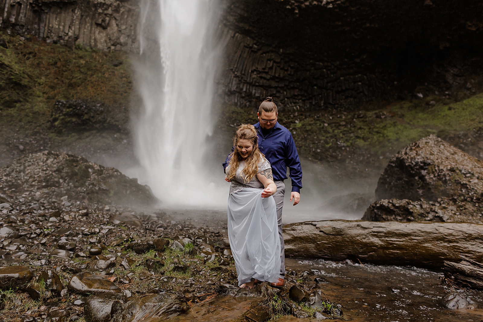 Couple walking by waterfall together 