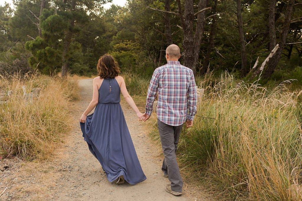 Couple holding hands walking on dirt trail together