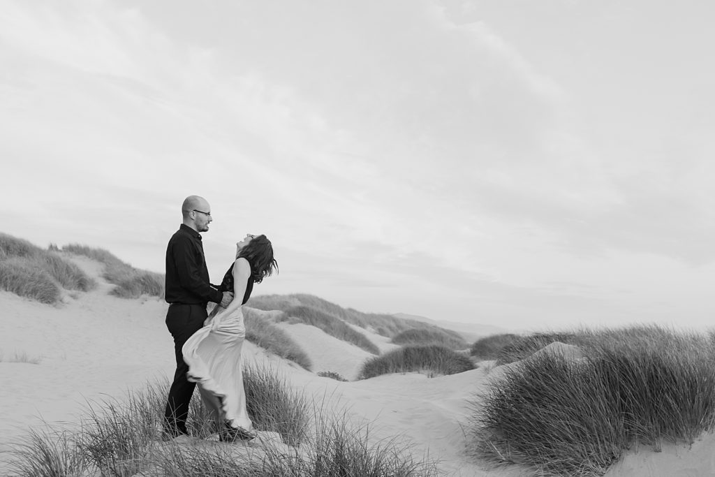 B&W of couple standing on sand together candid
