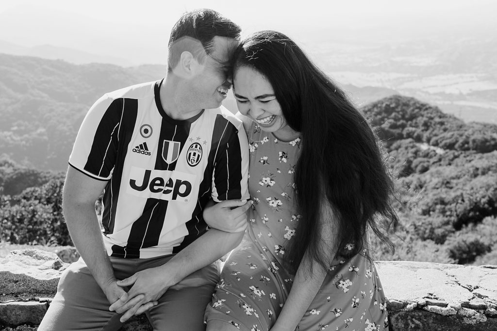 B&W portrait of couple sitting together and nuzzling with the mountains behind them Santa Barbara Proposal Photography captured by Oregon Engagement Photographer Simply Wandering Photography 