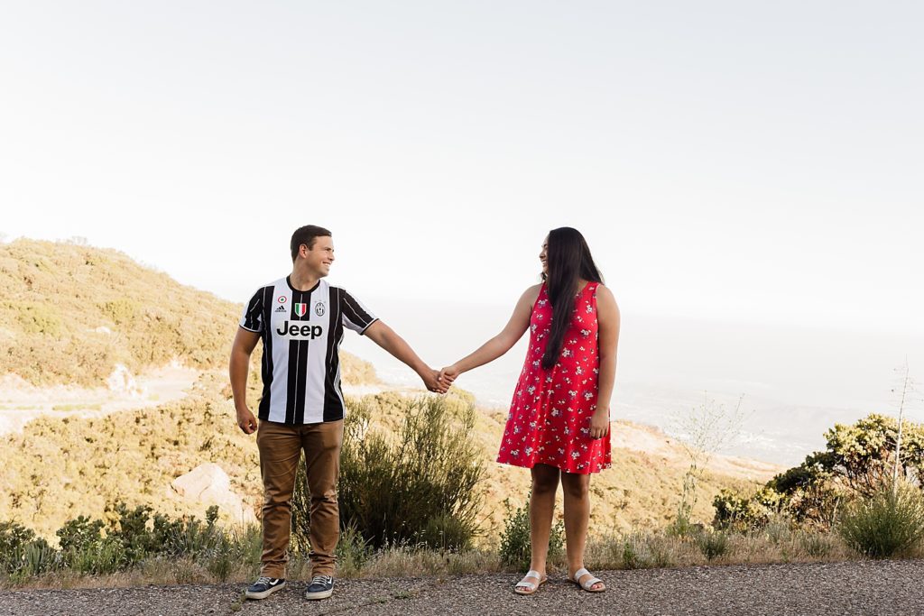 Couple extending their arms out and holding hands on dry terrain Santa Barbara Proposal Photography captured by Oregon Engagement Photographer Simply Wandering Photography  