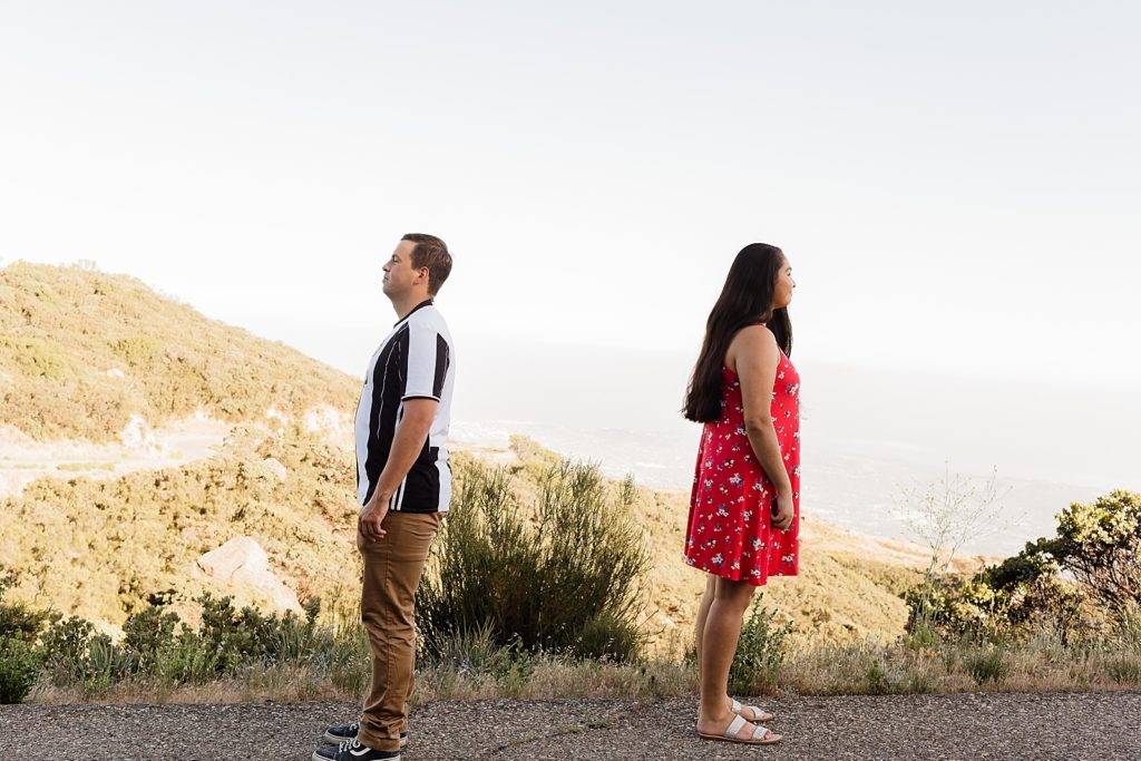 Couple standing with their backs turned from each other Santa Barbara Proposal Photography captured by Oregon Engagement Photographer Simply Wandering Photography 