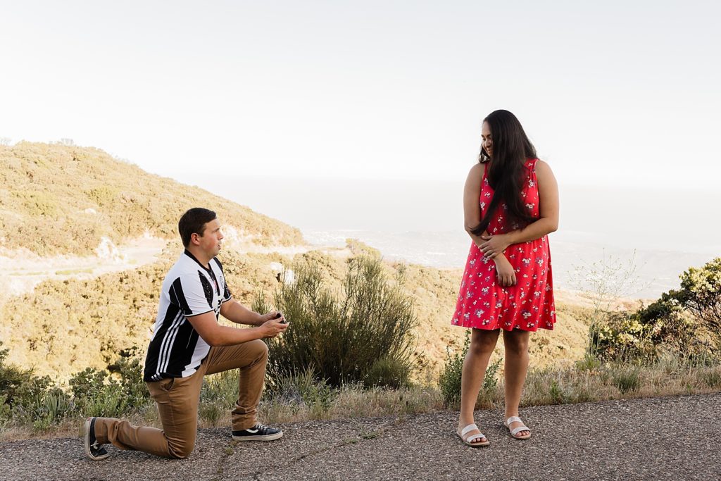 Woman turning seeing man proposing on one knee Santa Barbara Proposal Photography captured by Oregon Engagement Photographer Simply Wandering Photography 
