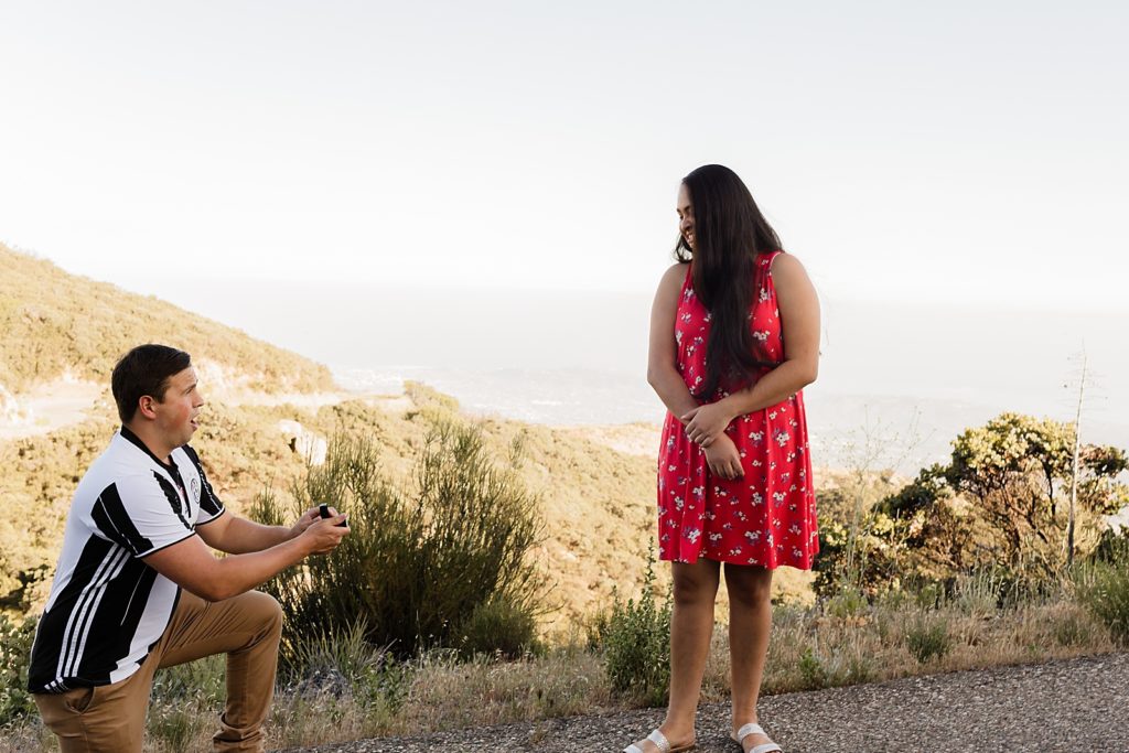 Man proposing on one knee to lady smiling in dry terrain Santa Barbara Proposal Photography captured by Oregon Engagement Photographer Simply Wandering Photography  
