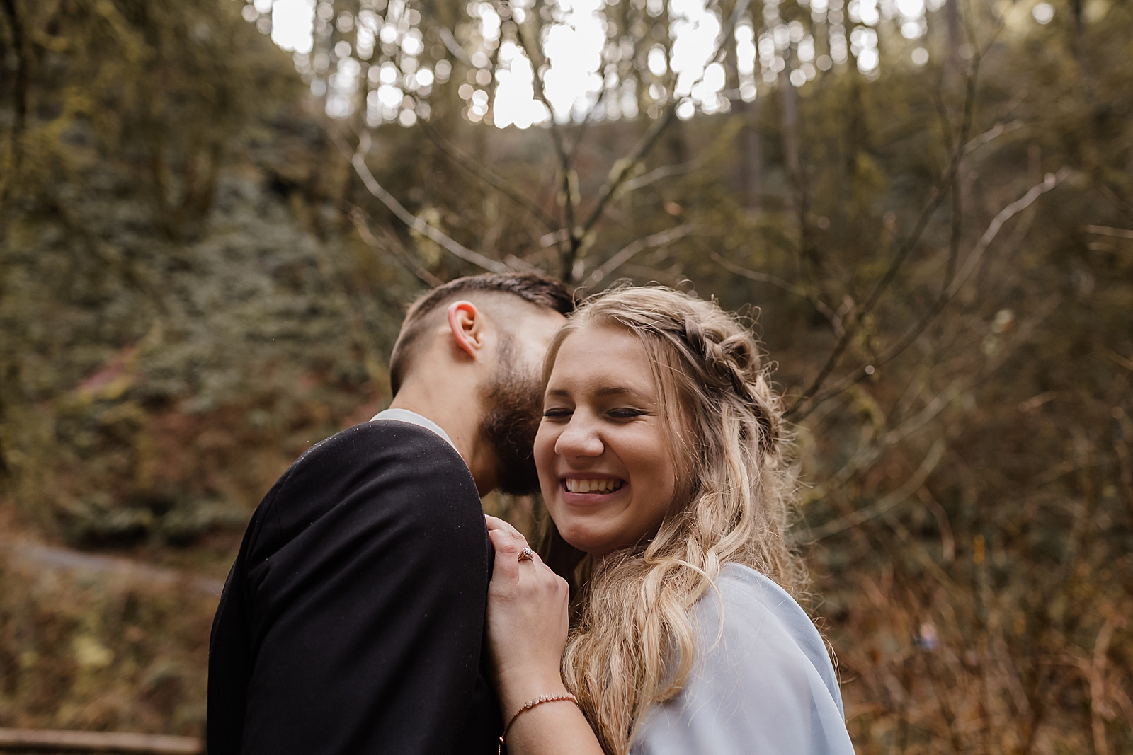 Man kissing lady on the cheek in the forest Silver Falls State Park Oregon Adventure Photography captured by Simply Wandering Photography 