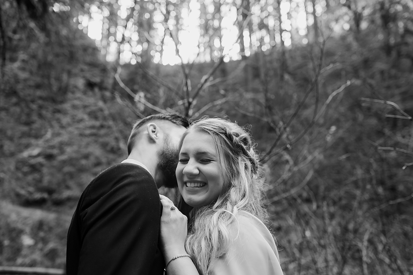 B&W Man kissing woman on the cheek in the forest Silver Falls State Park Oregon Adventure Photography captured by Simply Wandering Photography 