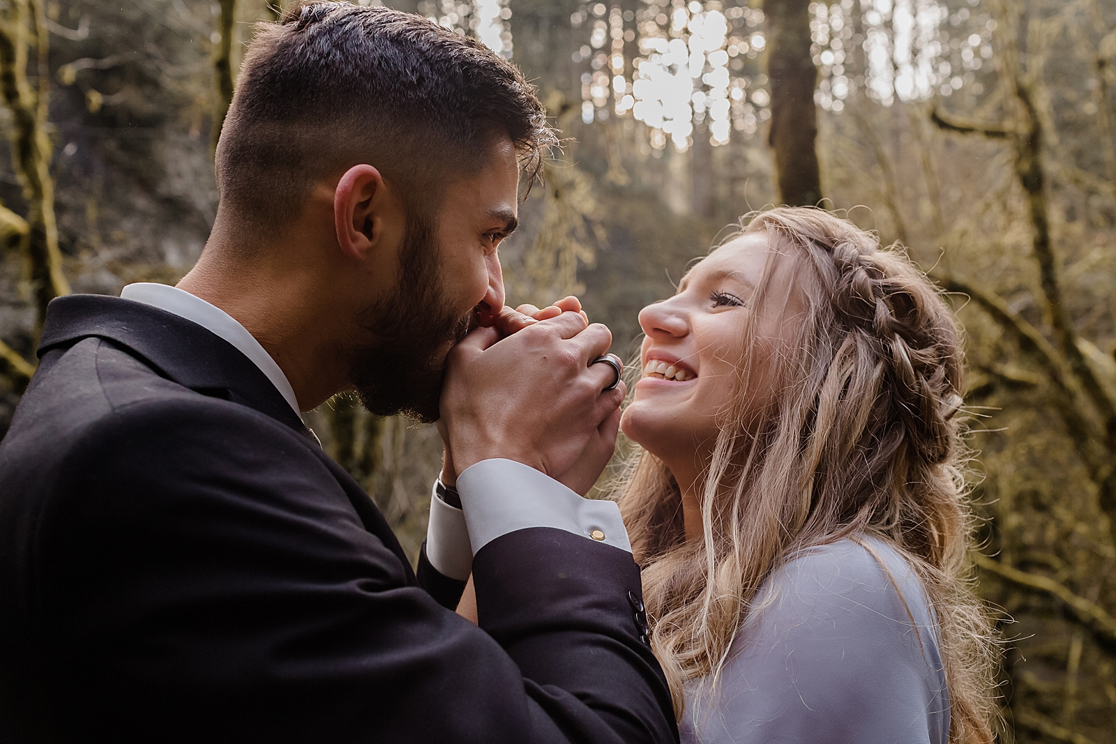 Man kissing woman's hand in the forest Silver Falls State Park Oregon Adventure Photography captured by Simply Wandering Photography 