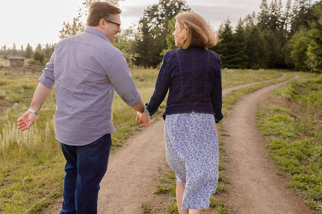 Couple holding hands walking on dirt path