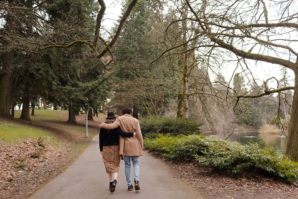 Couple with their arms around each other walking on the sidewalk together