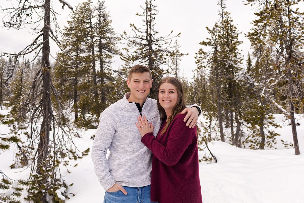Couple with arms around each other on snowy mountain side