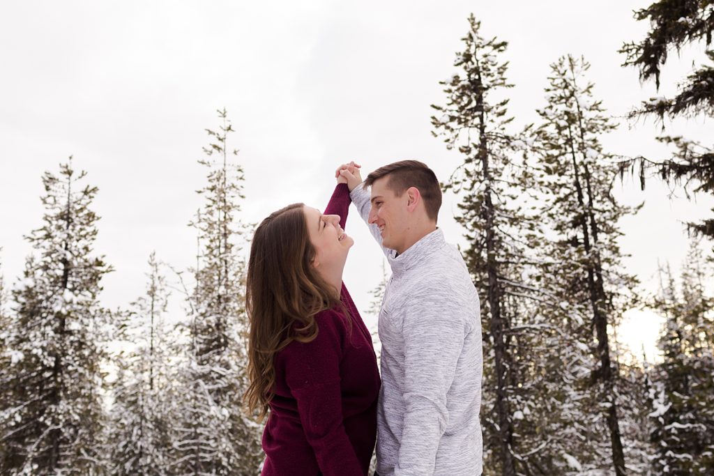 Couple dancing surrounded by snow forest trees