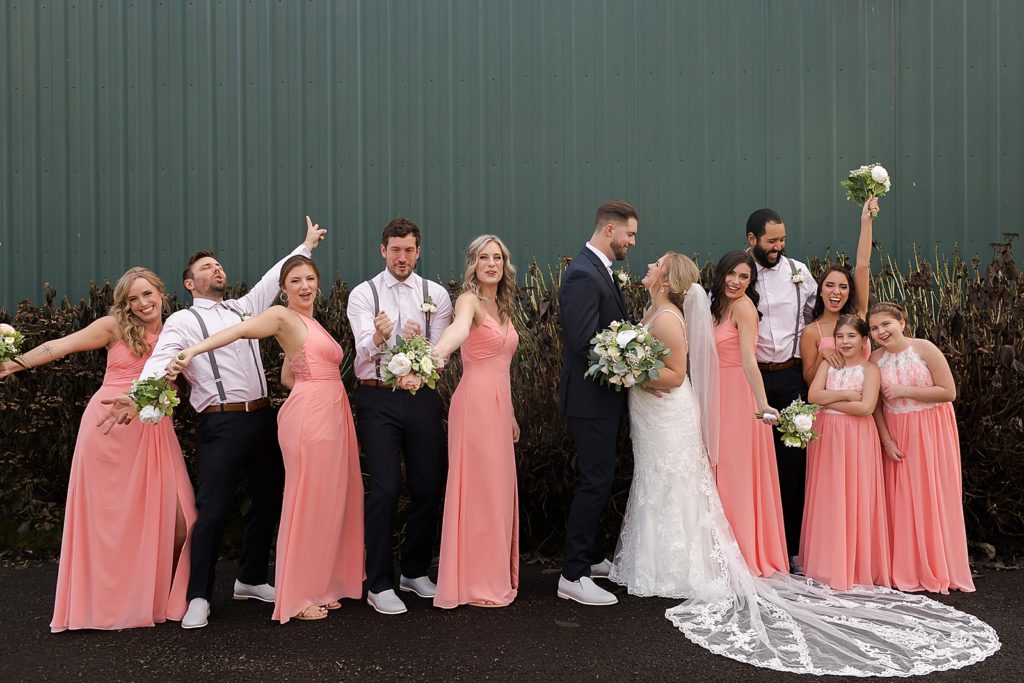 Bride and Groom holding each other close with Bridal party around them