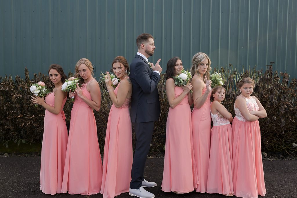 Groom doing back to back spy pose with Bridesmaids