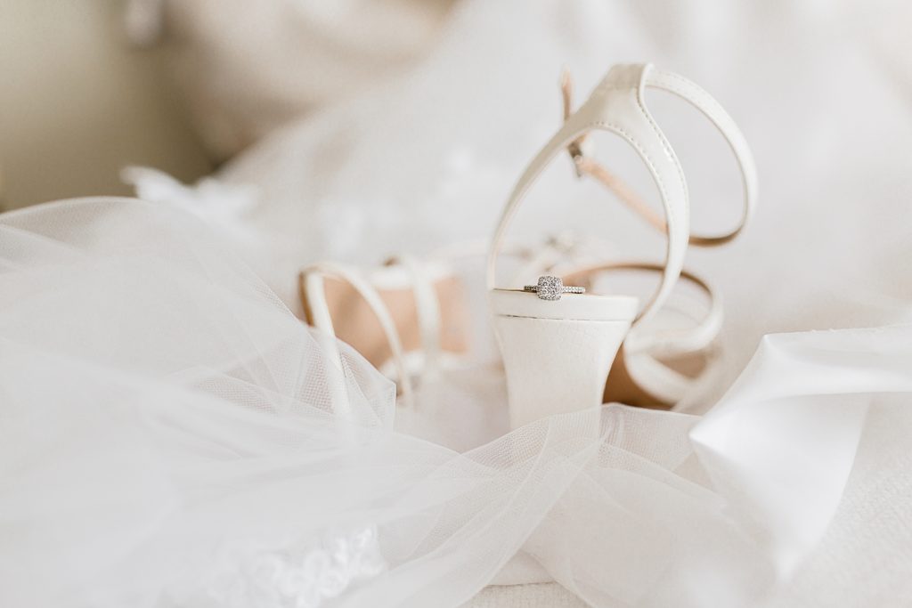 Detail shot of wedding heels with engagement ring