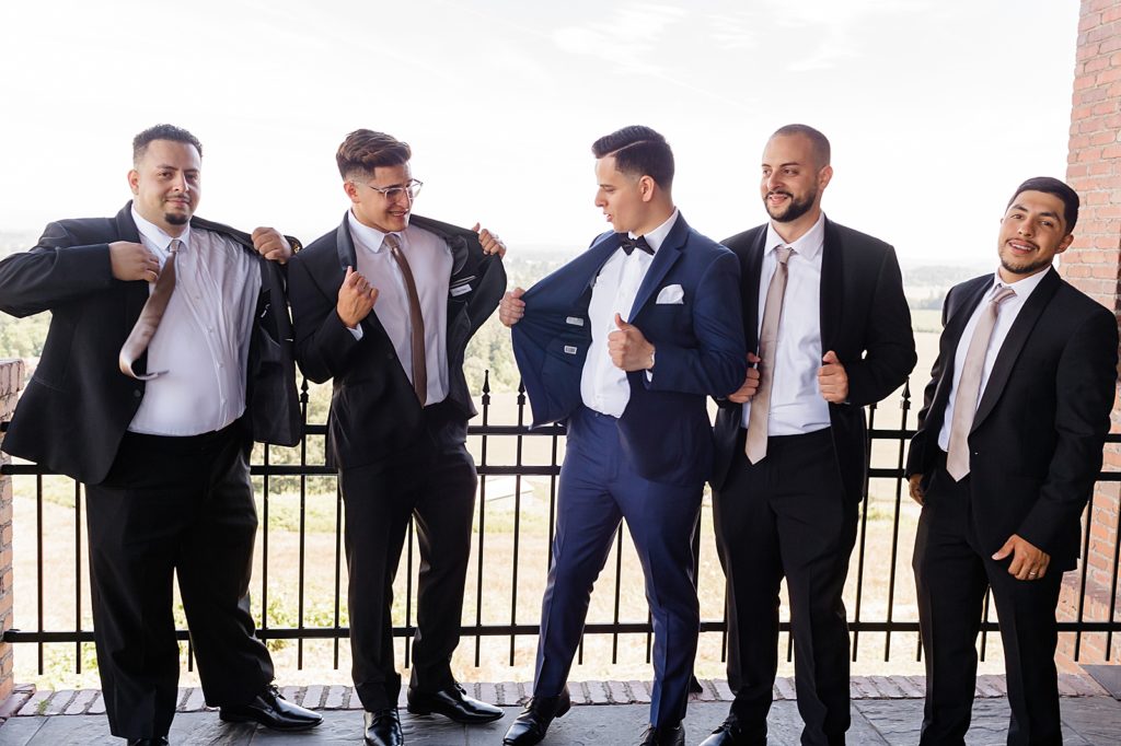 Groom and Groomsmen showing off their jackets to each other