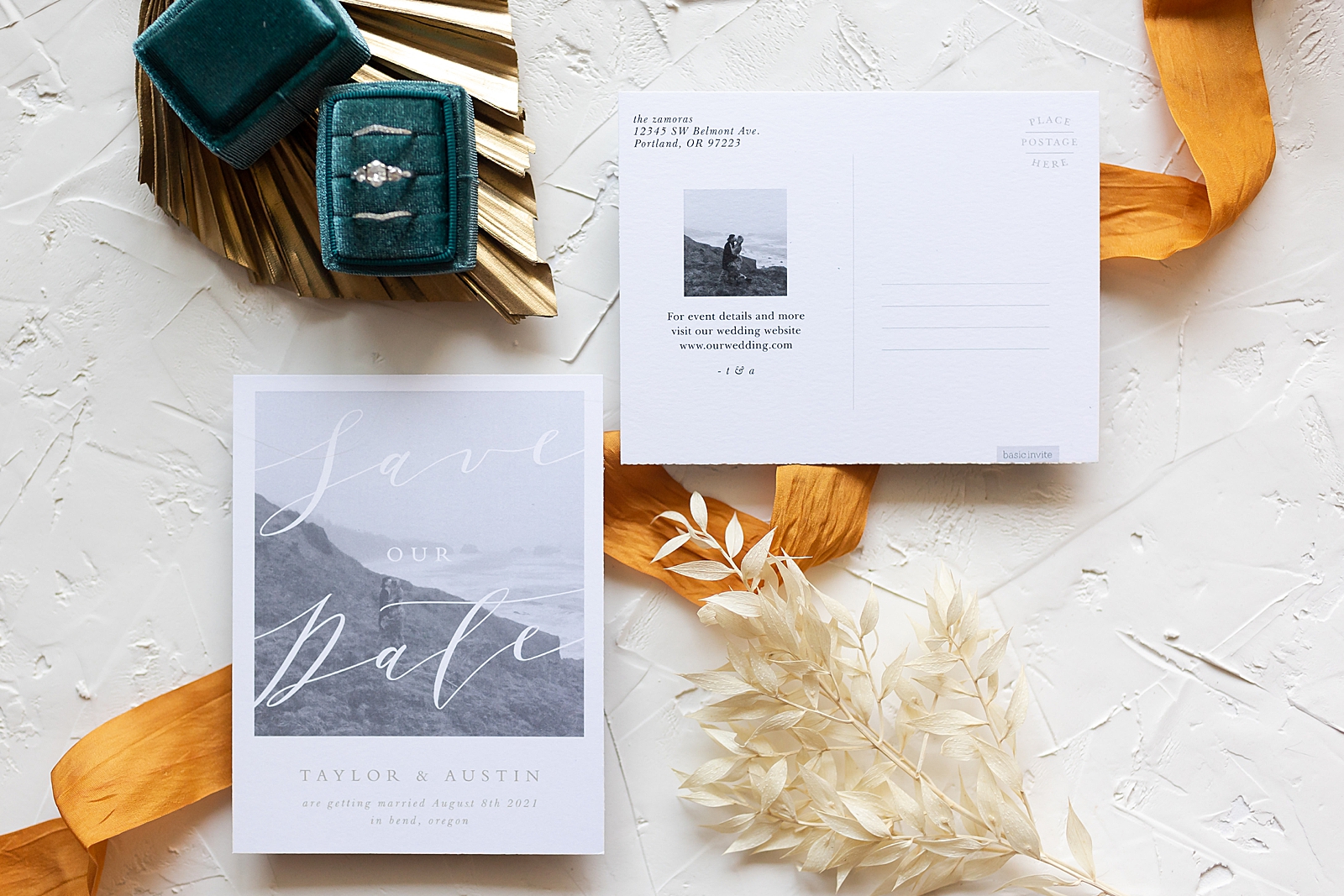 post card style save the date card on white table next to save the date card with engagement photo on it