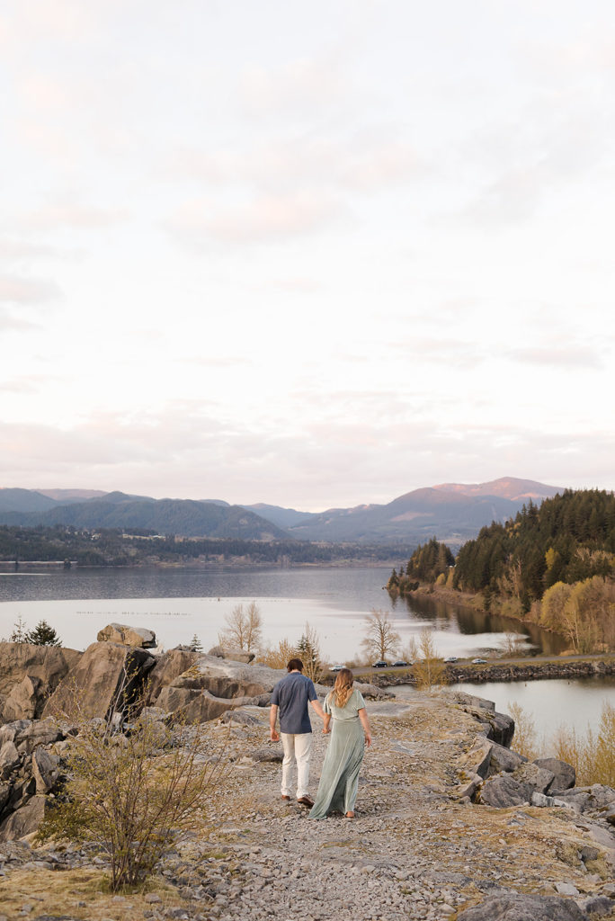 girl in green dress and guy in blue dress shirt looking out at columbia river