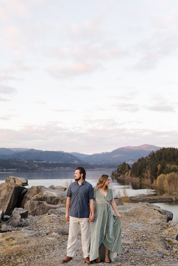 girl in green dress and guy in blue dress shirt looking out at columbia river