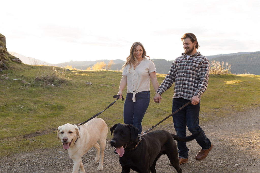 couple walking their two dogs during columbia river gorge engagement
